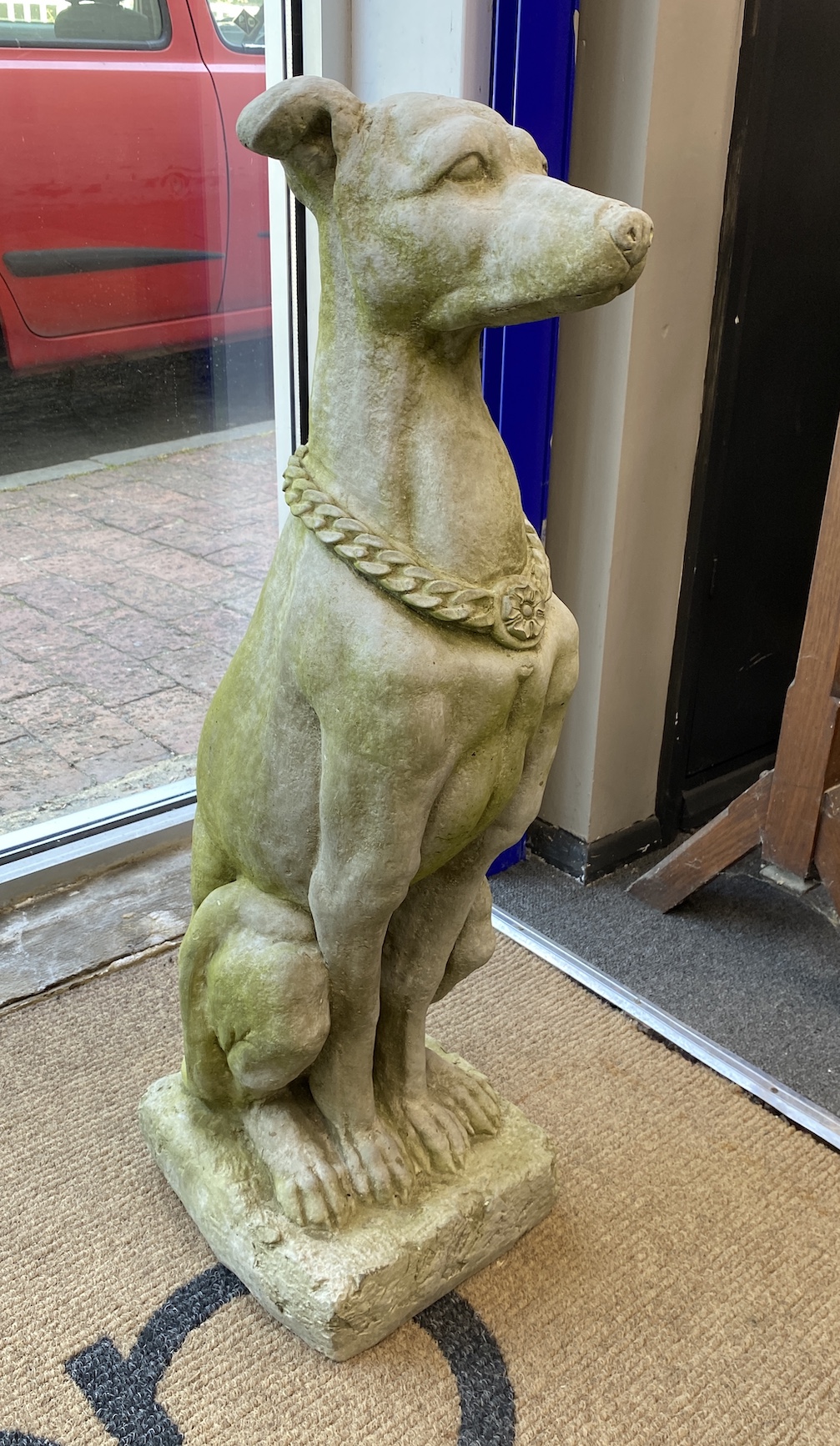 A pair of reconstituted stone seated greyhound garden ornaments, height 79cm